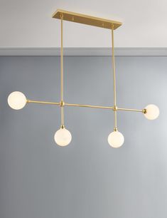 three lights hanging from a ceiling fixture in a room with gray walls and blue carpet