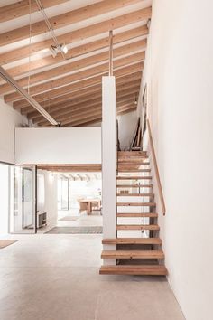 an empty room with wooden stairs and white walls