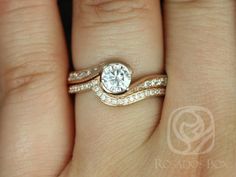 a woman's hand with a diamond ring on top of her finger and the bottom half of her wedding band