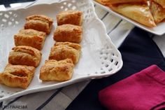 several pastries are sitting on a white tray next to a pink napkin and red towel