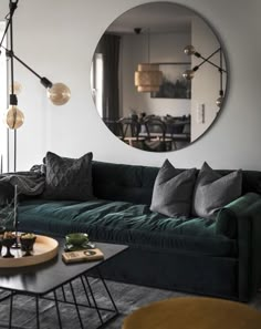 a living room filled with furniture and a round mirror