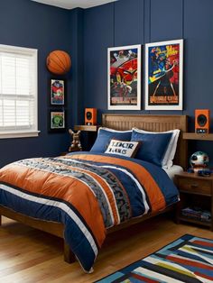 a bedroom decorated in blue and orange with pictures on the wall