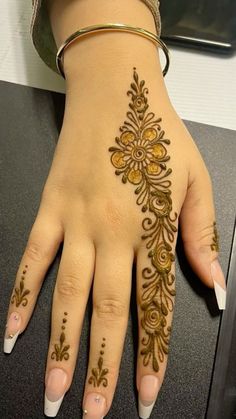 a woman's hand with henna tattoos on it