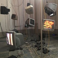 several televisions and monitors are tangled up in a room