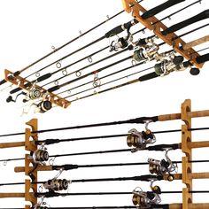 several fishing rods and reels are hanging from the ceiling in front of a white background