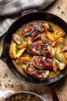 a skillet filled with meat and vegetables covered in gravy on top of a table