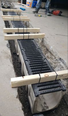 the man is standing next to several rows of grates in the ground, with one laying on top of each other