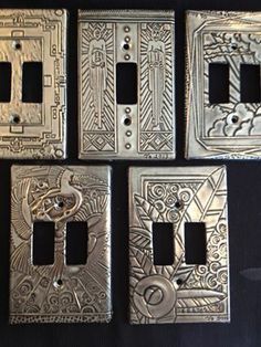 four metal switch plates with intricate designs on them, all in different shapes and sizes