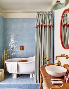 a bath room with a tub a sink and a mirror on the wall next to a window