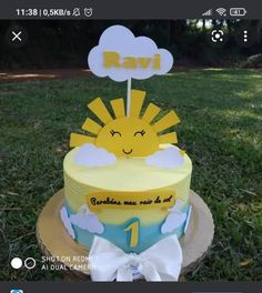 a yellow and blue cake sitting on top of a wooden stump in the middle of grass