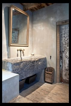 a bathroom with a sink, mirror and wooden crate in it's corner next to the door