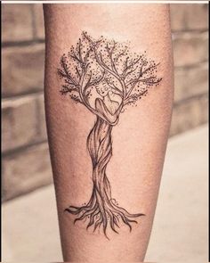 a woman's leg with a tree tattoo on it