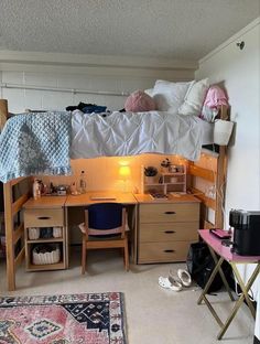 a dorm room with a desk, bed and rugs on the floor in front of it