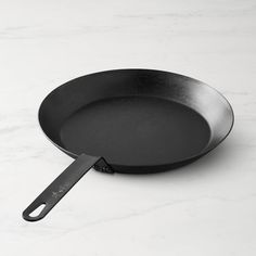 a black frying pan on a white counter top