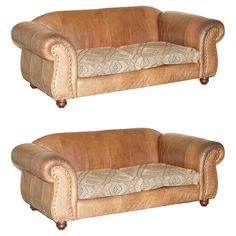 two brown leather couches sitting next to each other on top of a white background