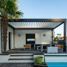 an outdoor living area with wooden floors and white walls