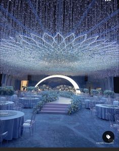 an elaborately decorated wedding venue with chandeliers and blue linens on the ceiling