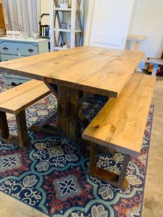 a wooden table and bench sitting on top of a rug