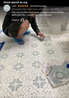 a person kneeling down on the floor in front of a toilet