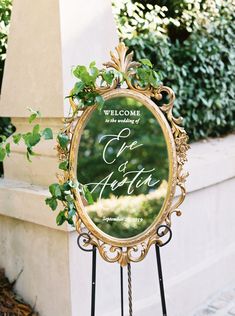 a welcome sign is shown in front of a mirror with greenery on the frame