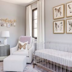 a baby's room with a crib, chair and pictures on the wall