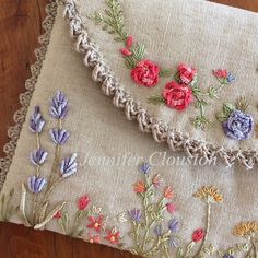 a close up of a piece of cloth on a wooden floor with flowers embroidered on it