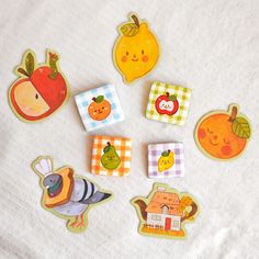 small wooden magnets with pictures of fruits and vegetables on them are laying on a towel