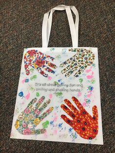 a bag with hand prints on it sitting on the floor in front of a carpet