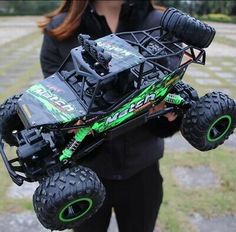 a woman holding up a remote controlled monster truck