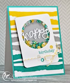 a handmade birthday card with the word happy on it, and a green striped background