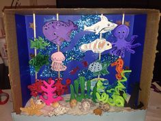 an ocean scene made out of cardboard with sea animals and fish on sticks in it