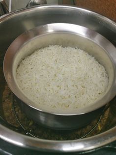 a bowl filled with rice sitting on top of a stove