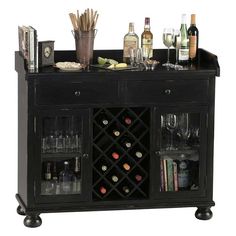 a black bar with wine glasses and bottles on the top, next to an assortment of liquors