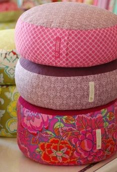 four colorful pillows stacked on top of each other