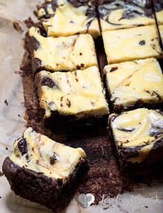 there are chocolate brownies with yellow frosting on the top and one is cut into squares