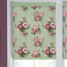 the window is decorated with pink flowers and green wallpaper, along with two matching roller shades