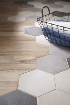 a basket that is sitting on the floor next to a towel and some blue towels