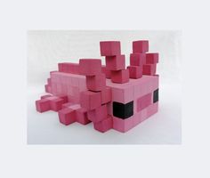 an image of a pink blocky toy that is made out of lego blocks and has black eyes