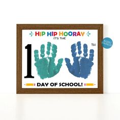 two handprints with the number one on them are displayed in front of a wooden frame