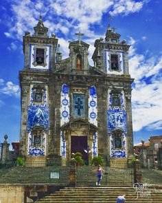 an old church with blue and white tiles on it's front door, surrounded by steps