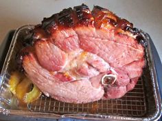 a large piece of meat sitting on top of a metal pan next to some fruit