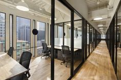 an office with glass walls and wooden floors