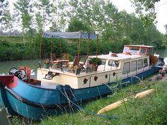 a blue and white boat sitting on top of a river