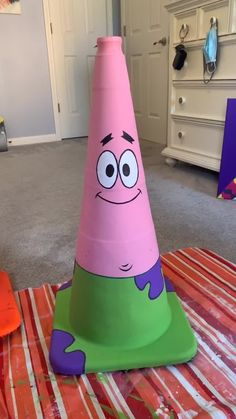 a pink and green cone sitting on top of a bed