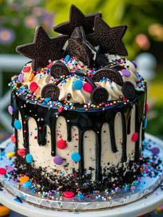 a birthday cake with oreo cookies and sprinkles on top is sitting on a plate