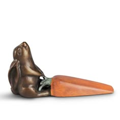 a bronze statue of a dog with a carrot shaped like it's head sticking out of its mouth