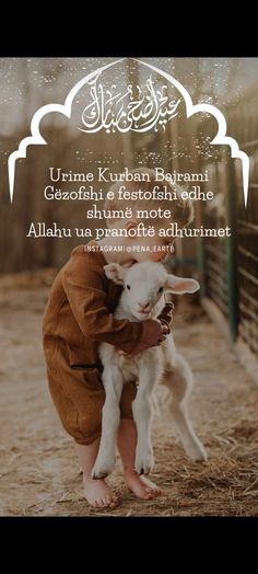 a person kneeling down to pet a small goat in front of a fence with an arabic quote on it