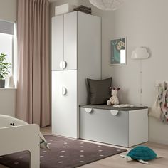 a child's bedroom with white furniture and pink curtains