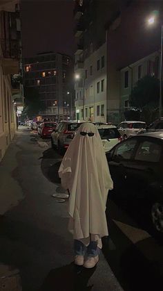 a person in a white cloak standing on the street