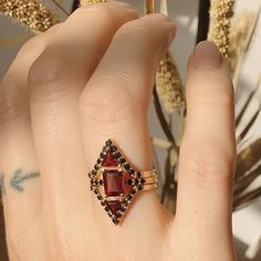 Beautifully stunning, this Deco-inspired ring features Garnet and black diamonds and is sure to turn heads. Black Ruby Rings As Gift, Black Ruby Rings For Gift, Black Ruby Rings For Gifts, Black Ruby Ring Jewelry, Black Ruby Jewelry For Wedding, Black Ruby Wedding Jewelry, Wedding Black Ruby Jewelry, Black Ruby Ring For Anniversary, Formal Black Rings With Ruby